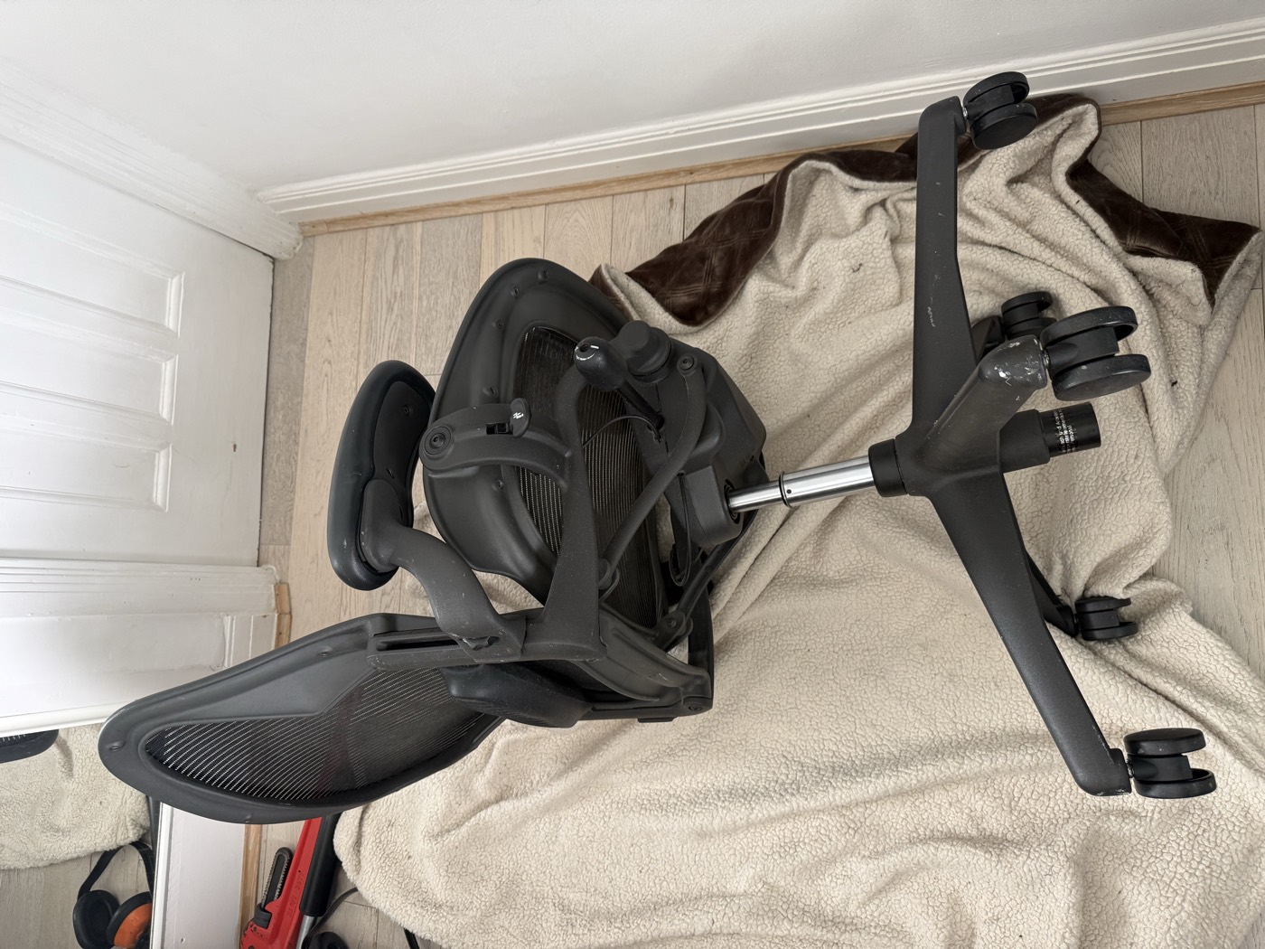Herman Miller Aeron chair being repaired on-site at a London home, laid on a protective blanket